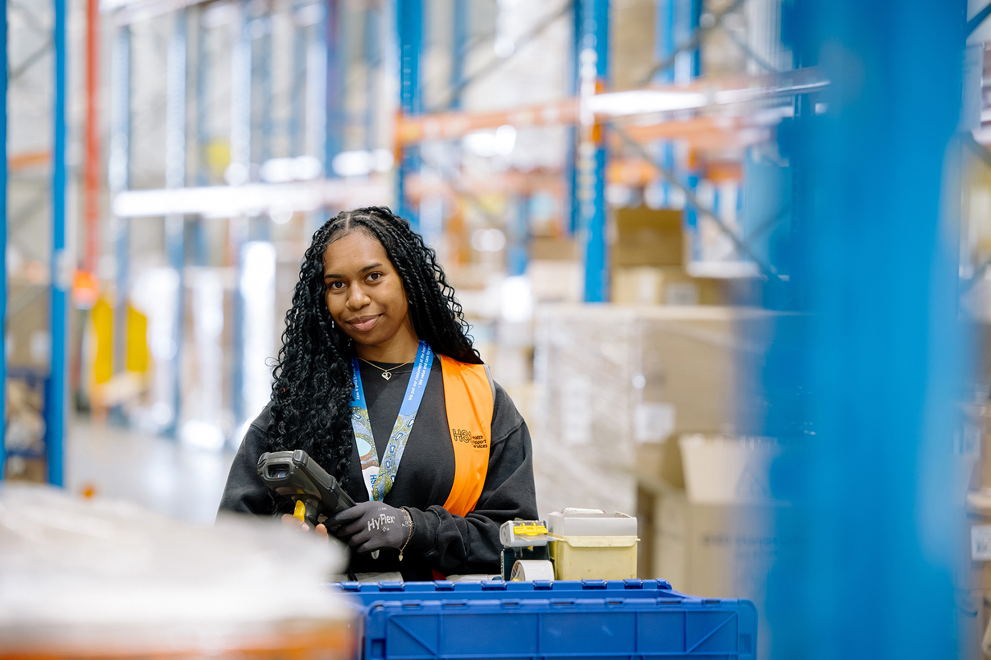 Person in a warehouse environment holding a scanner