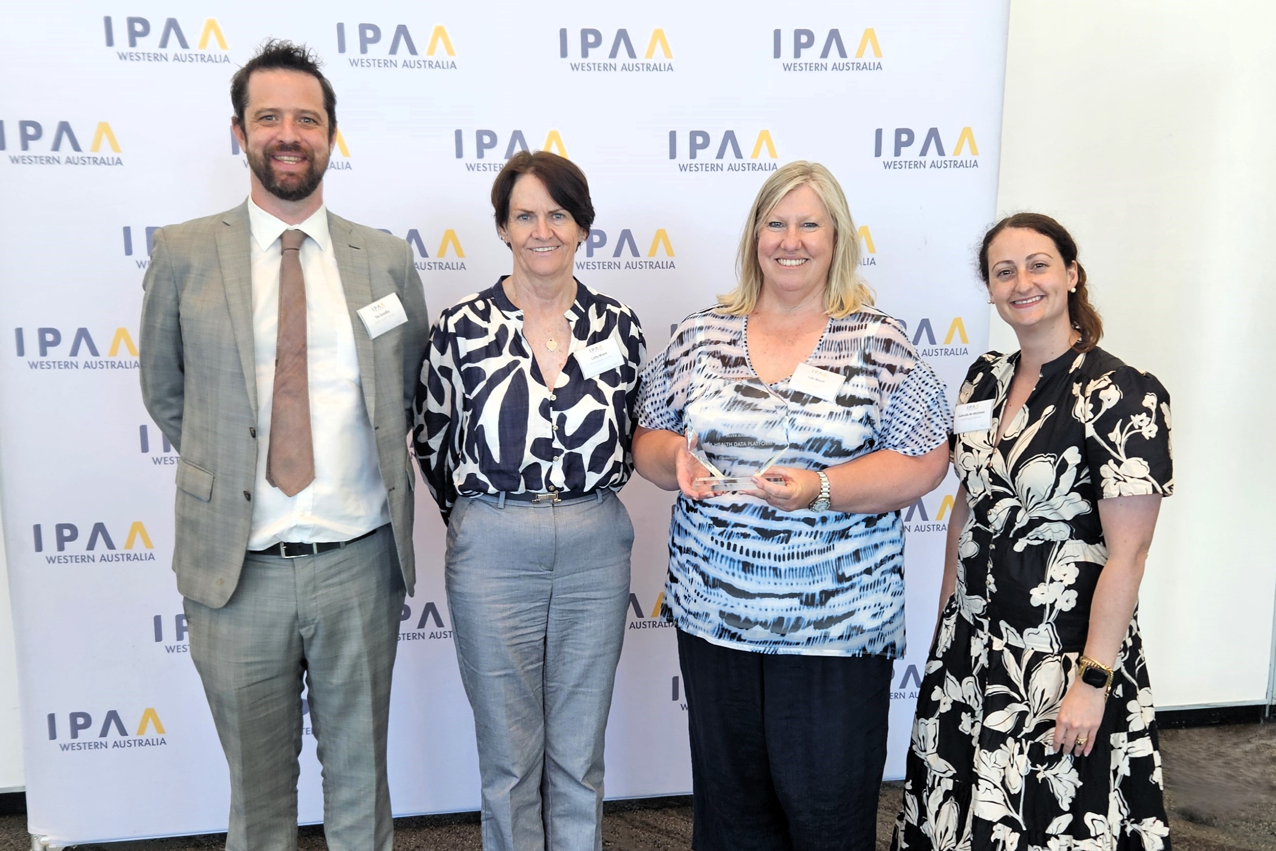People standing together holding an award